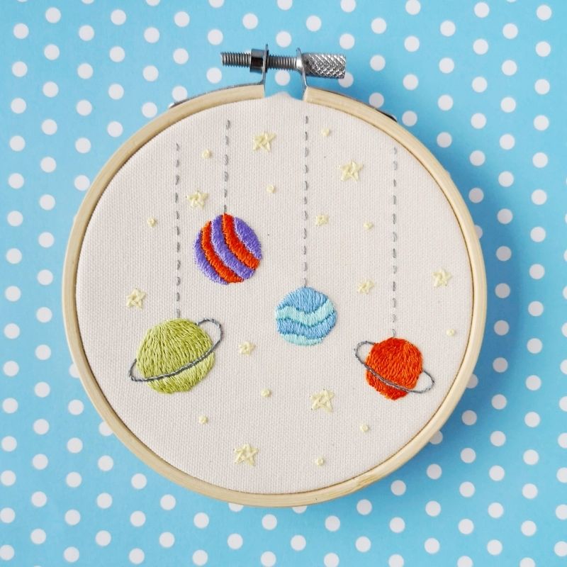 Toy galaxy embroidery design. Planets on the strings and stars. Embroidery in a hoop