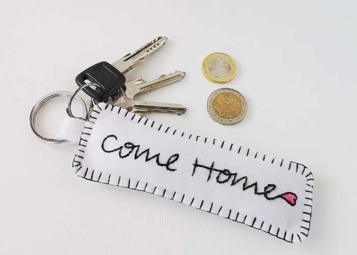 Keyring with embroidered phrase come home and a heart, keys and two coins