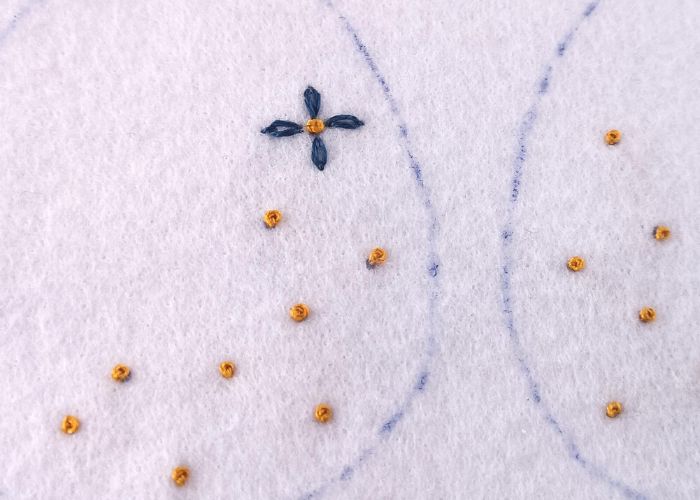 Make four petals with the Detached chain stitch