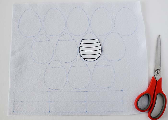 Cut away the top shape of the pattern, place it on one of the shapes to embroider, and draw the line