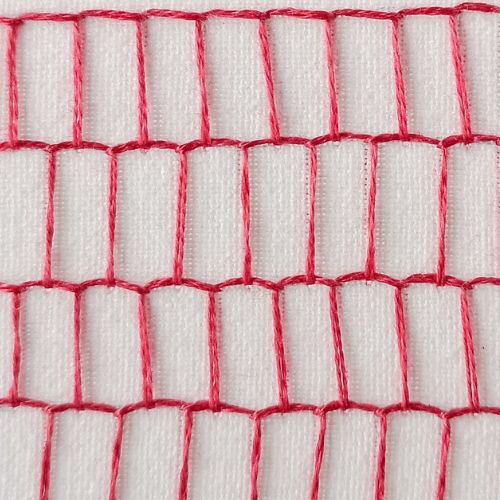 Imbottitura a punto coperta con fili rossi su tessuto bianco