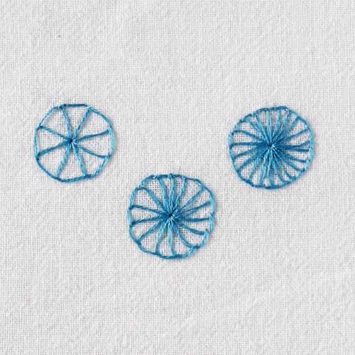 Buttonhole wheel embroidery stitch on white fabric with blue floss