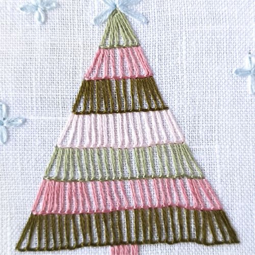 Arbre de Noël brodé avec des fils colorés et des points de couverture