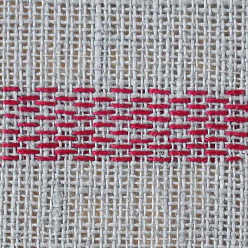 Darning stitch with red thread on natural linen