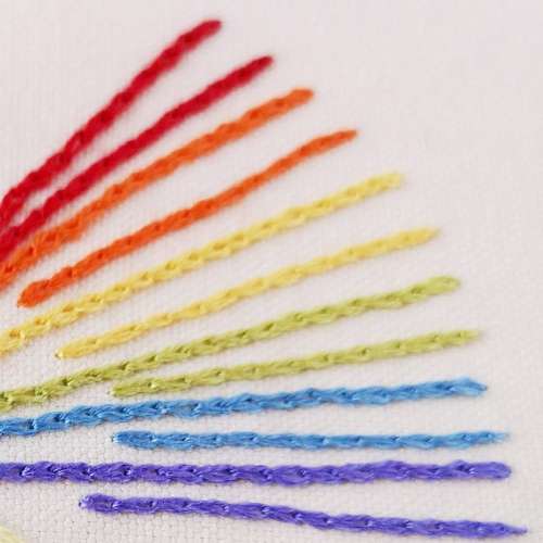 Rainbow hand embroidered on white linen fabric