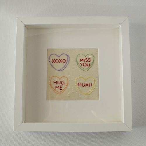 Candy hearts embroidery framed in a square photo frame