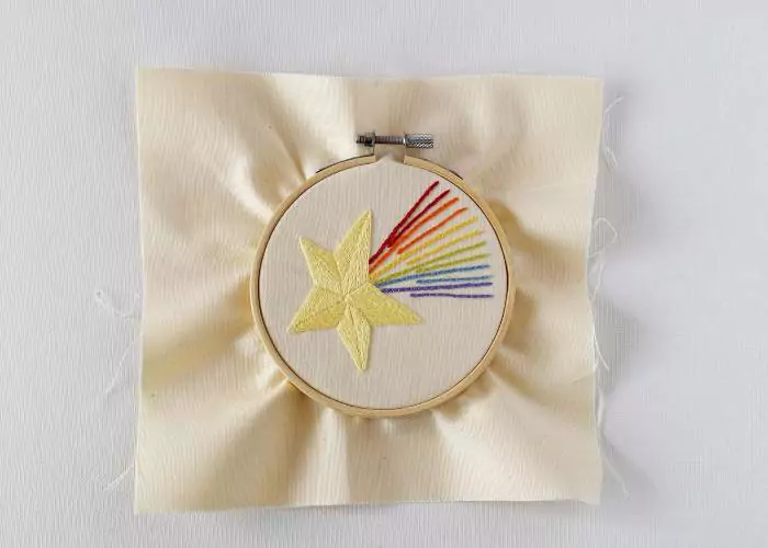 Frame the fabric with your embroidery centered in a hoop and tighten the screw.