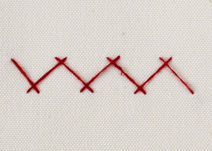 Herringbone stitch embroidery on white linen