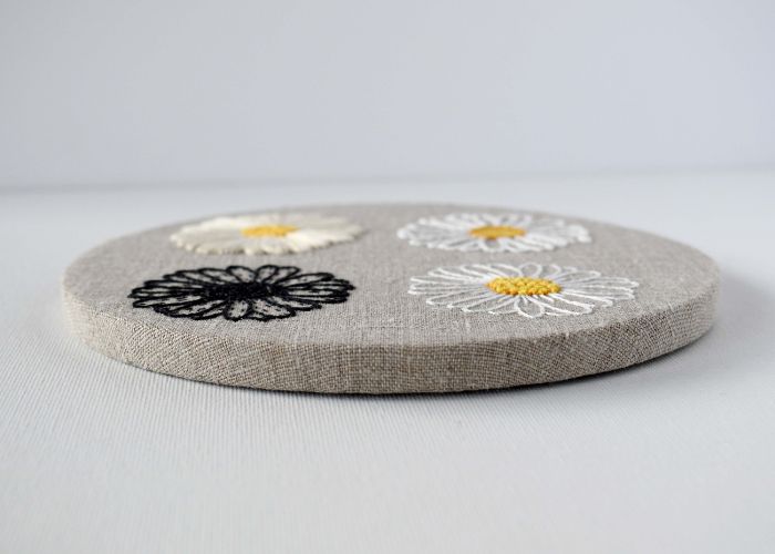 Natural linen fabric with floral embroidery framed without the outer hoop