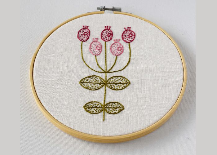 Pink floral embroidery framed in bamboo hoop with glue