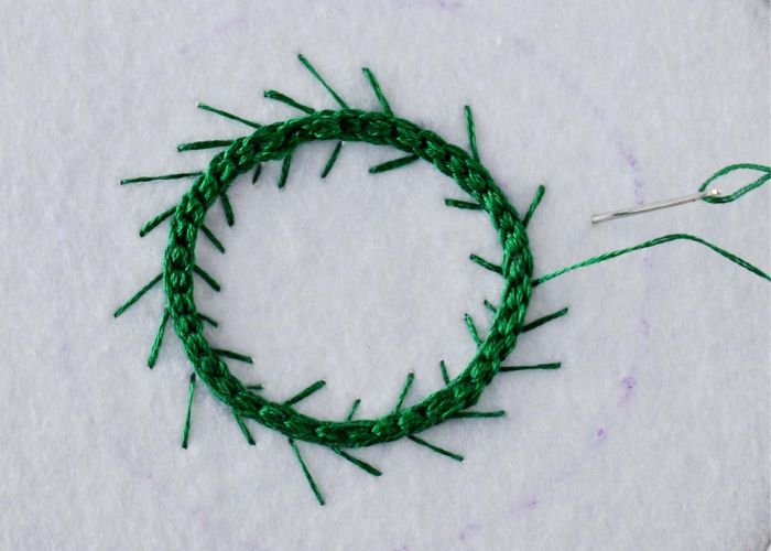 Add branches to the wreath with straight stitches