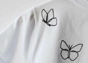 Practical Embroidery blog and online school : image black butterfly outline on white t-shirt just on practical embroider blog and online school 