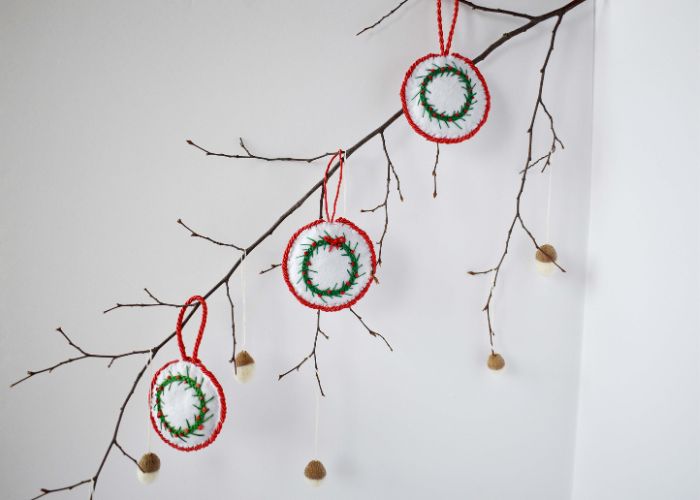 Tree branch decorated with DIY ornaments and acorns