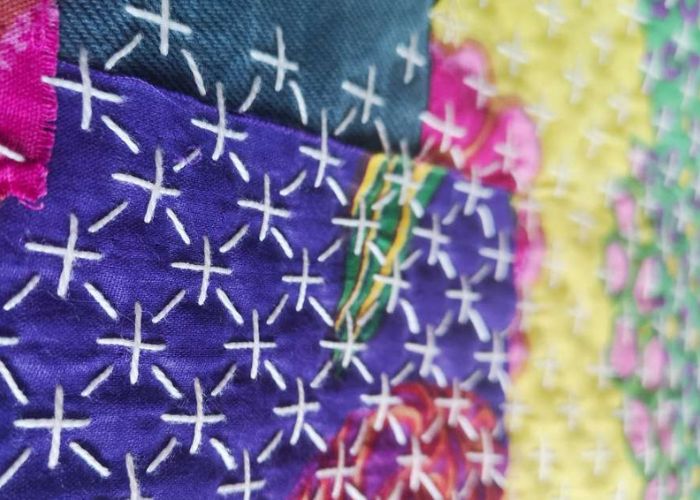 White sashiko stitches on purple fabric