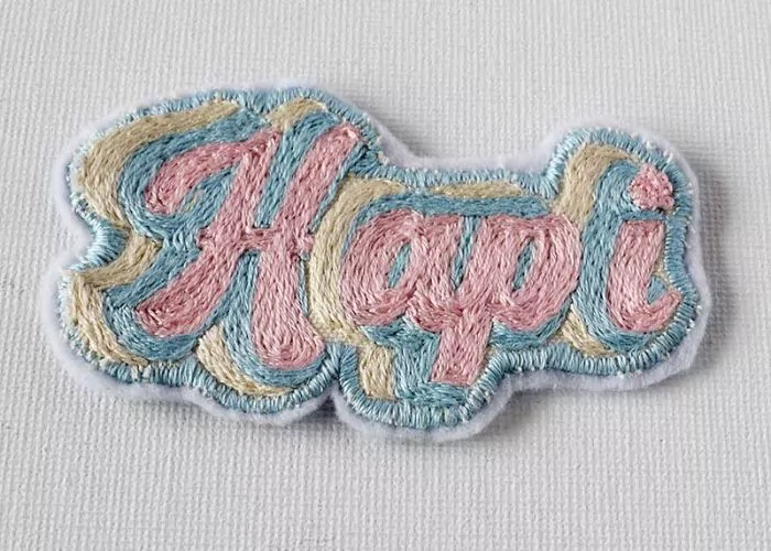 Hand embroidered patch with retro lettering: visible Mending knitwear