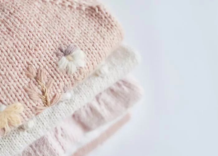 Mending knitwear: Pink knits with floral embellishments