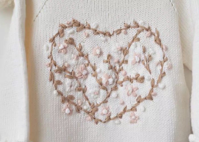knitted mending: White sweater with floral heart embroidery