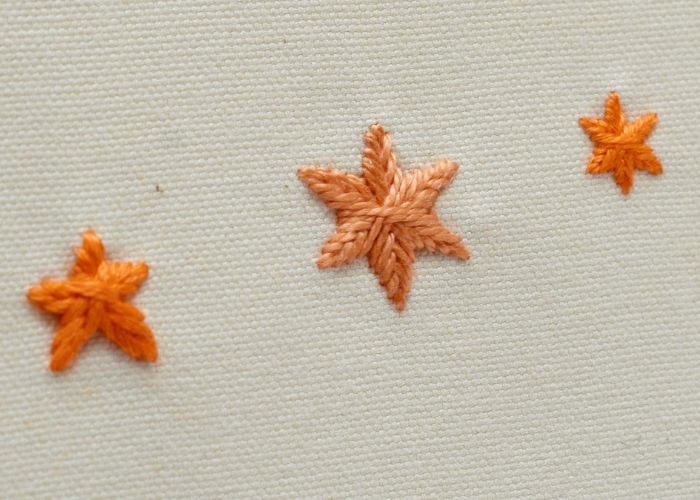 Woven Star Stitch - filled stars embroidery with orange floss