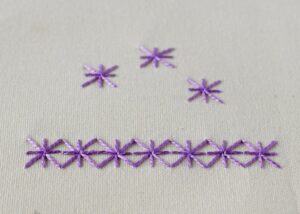 hand embroidery Algerian Eyelet stitch with purple threads hand embroidery Algerian Eyelet stitch with purple threads