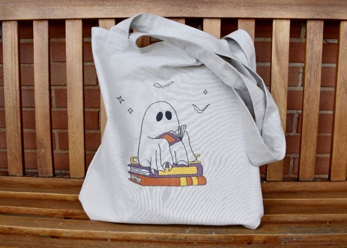 DIY hand embroidered tote bag with a cute reading ghost design