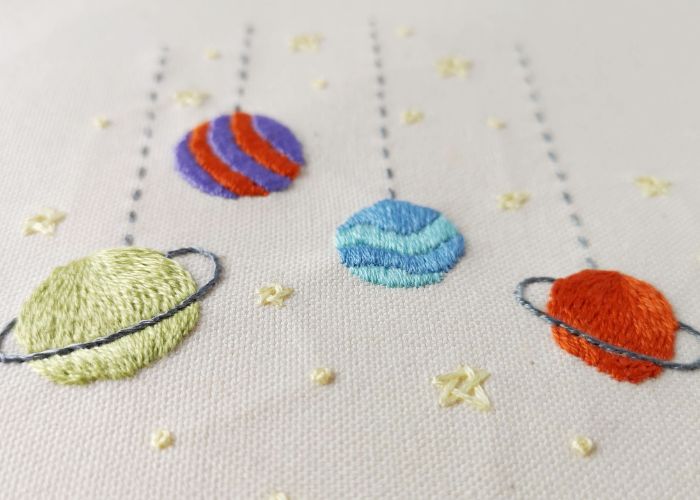 Toy Galaxy pattern highlighting Satin, Long and short, stem, woven star stitches