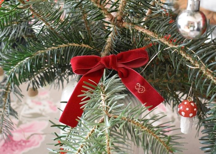 Lazo de cinta de terciopelo con monograma en un árbol de Navidad