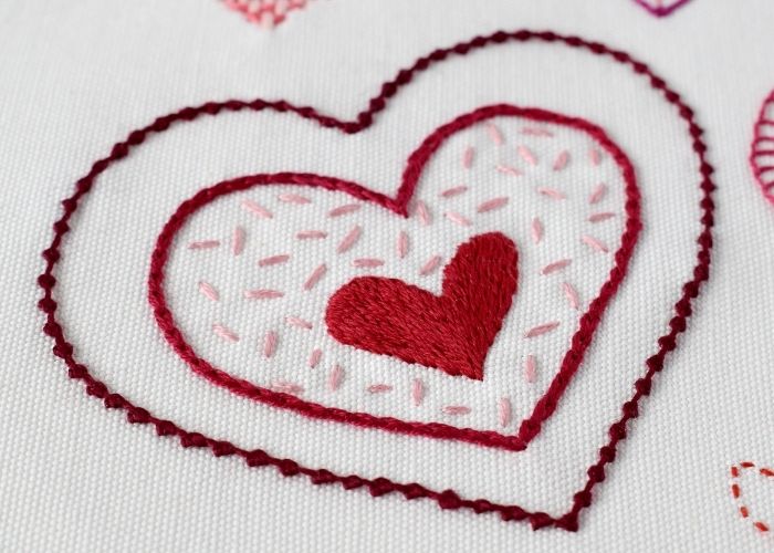 Decorative heart embroidery on white linen fabric