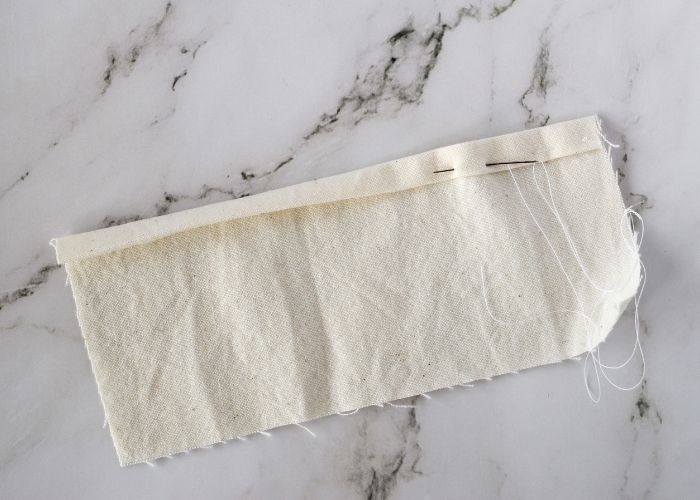 Basting a folded hem with running stitch image