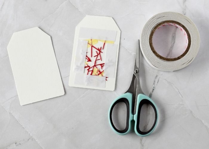 Assembling embroidered gift tag with double sided tape image