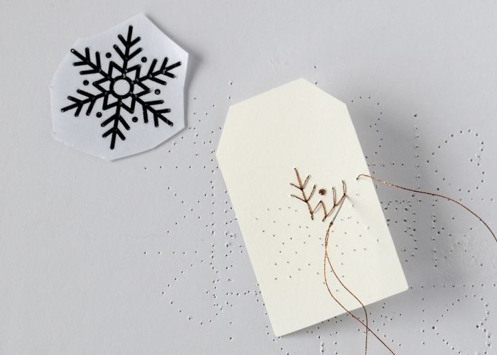 Embroidery process on a paper gift tag image