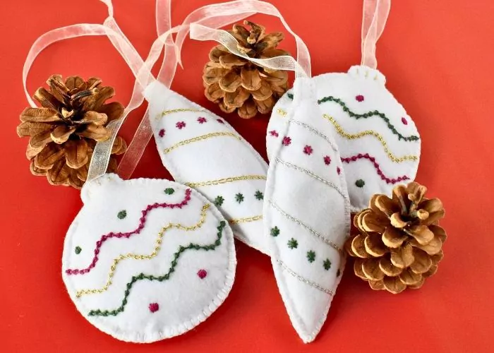 Felt hand embroidered Christmas ornaments on red background image