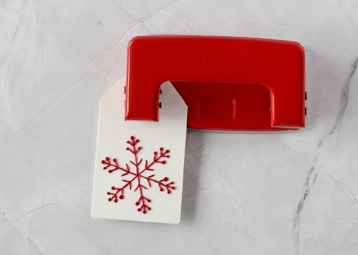Making a hole in a gift tag with a hole puncher image