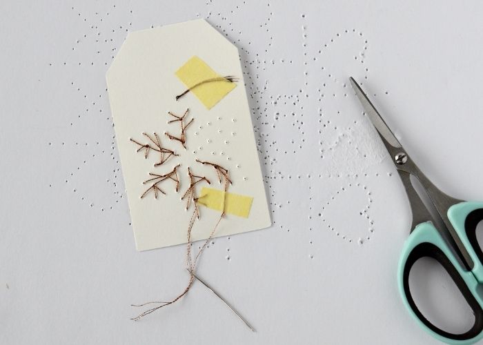 Securing the thread on the back in paper embroidery image