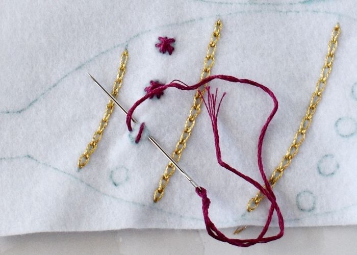 Star stitch embroidery with red floss on felt ornament image