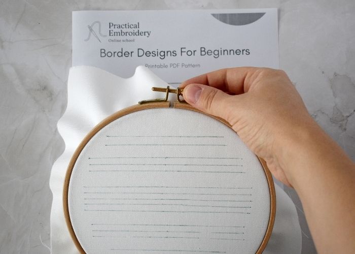 White fabric with a design stretched in the hoop image