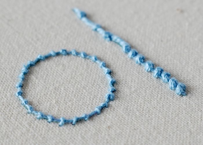 Immagine del ricamo a mano a punto perla con filo di cotone blu perlato