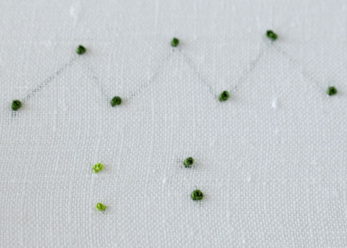 French Knots hand embroidered on light linen fabric with green floss image
