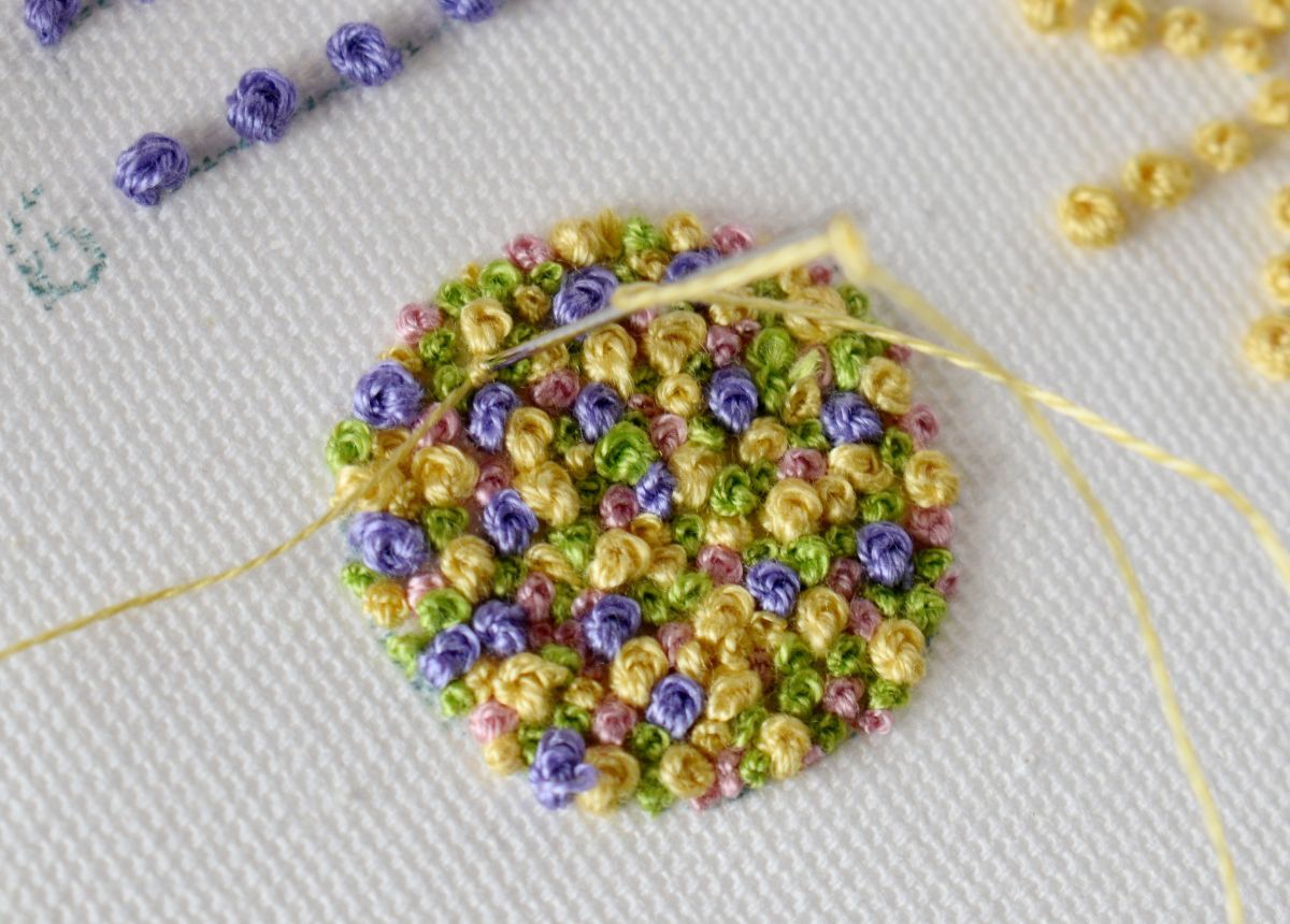 Filling small gaps in the design with tiny french knots made with single strand of embroidery floss