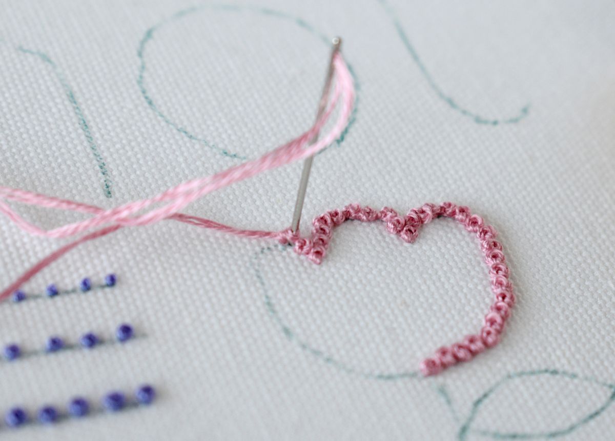 Hand embroidery Outlines with French Knot stitch and pink embroidery floss on white fabric